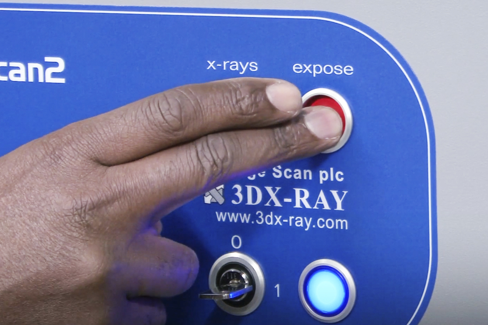 Control panel of a portable X-ray security scanner showing the X-ray exposure button during system operation.