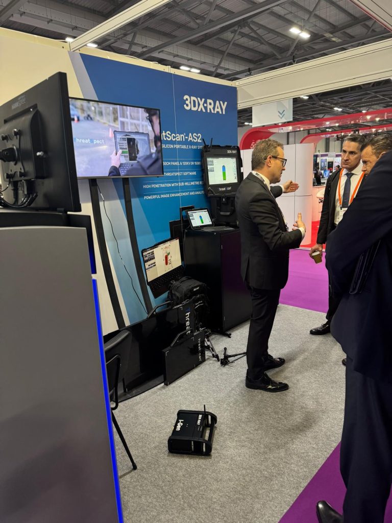 3DX-RAY exhibition stand showcasing portable X-ray scanning equipment, with attendees discussing products and demonstrations on display.